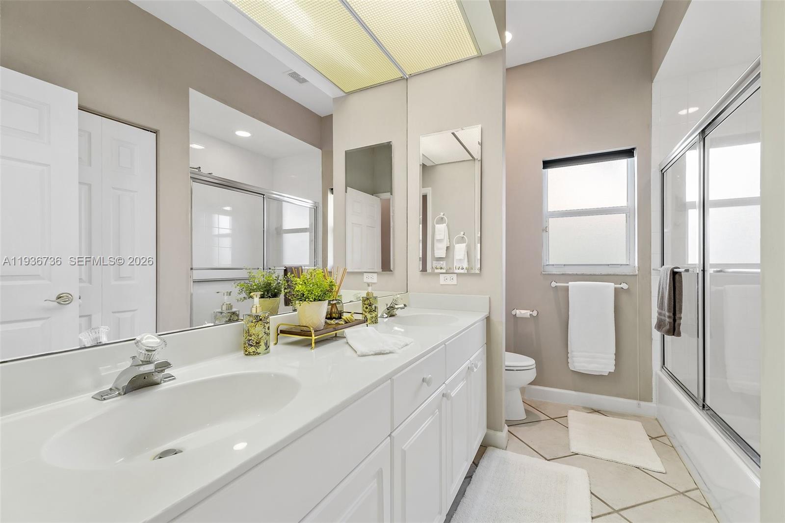 8185 Southeast Double Tree Drive Hobe Sound, FL 33455 - Photo 28 of 40 a bathroom with a double vanity sink toilet and shower