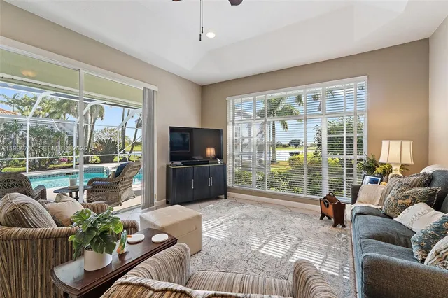 a living room with furniture floor to ceiling window and wooden floor