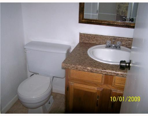 7222 Owen Court, Unit 1 Corpus Christi, TX 78413 - Photo 8 of 10 a bathroom with a granite countertop toilet sink and mirror