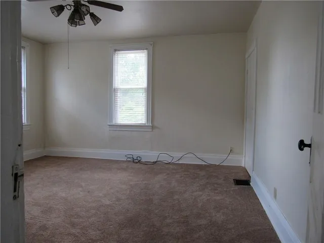 an empty room with fan and windows