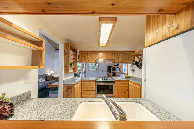 a view of a kitchen with kitchen island stainless steel appliances a stove and a window