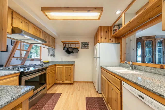 a kitchen with stainless steel appliances granite countertop a sink stove and refrigerator