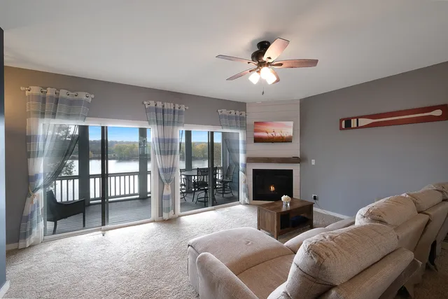 a living room with furniture a fireplace and chandelier