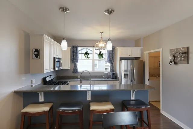a kitchen with a table chairs stove and cabinets