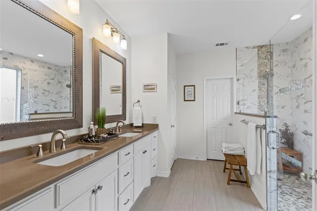 a spacious bathroom with double sink and a mirror