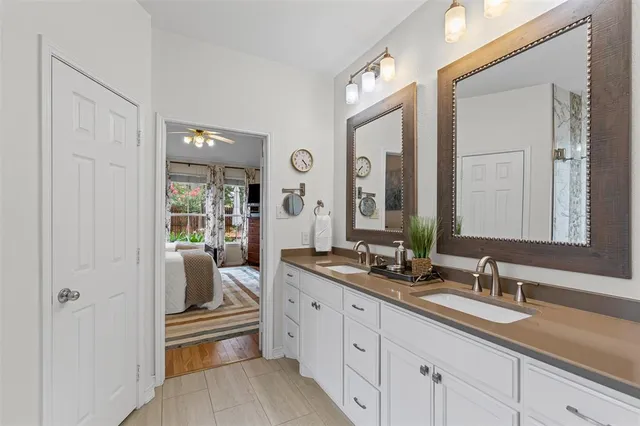 a en suite bathroom with a granite countertop sink and a mirror