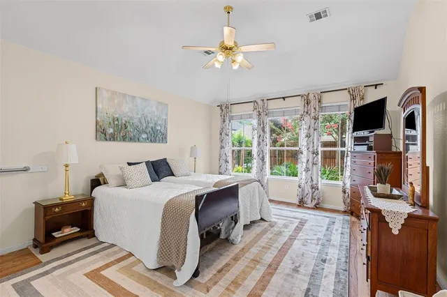 a bedroom with a bed a flat screen tv and a large window