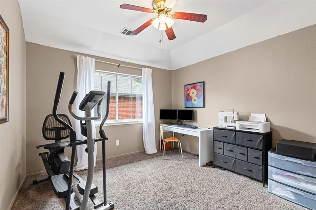 a view of a workspace with furniture and a window