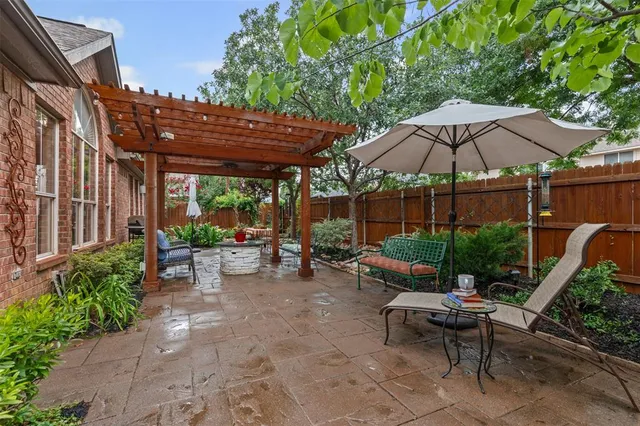 a view of a patio with table and chairs potted plants with wooden floor and fence