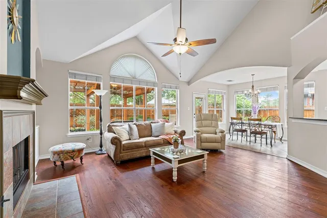 a living room with furniture fireplace and a large window