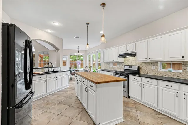 a kitchen with stainless steel appliances granite countertop a stove a sink and a refrigerator