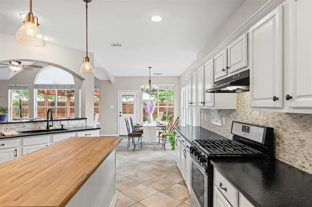 a kitchen with stainless steel appliances granite countertop a stove a sink and a microwave