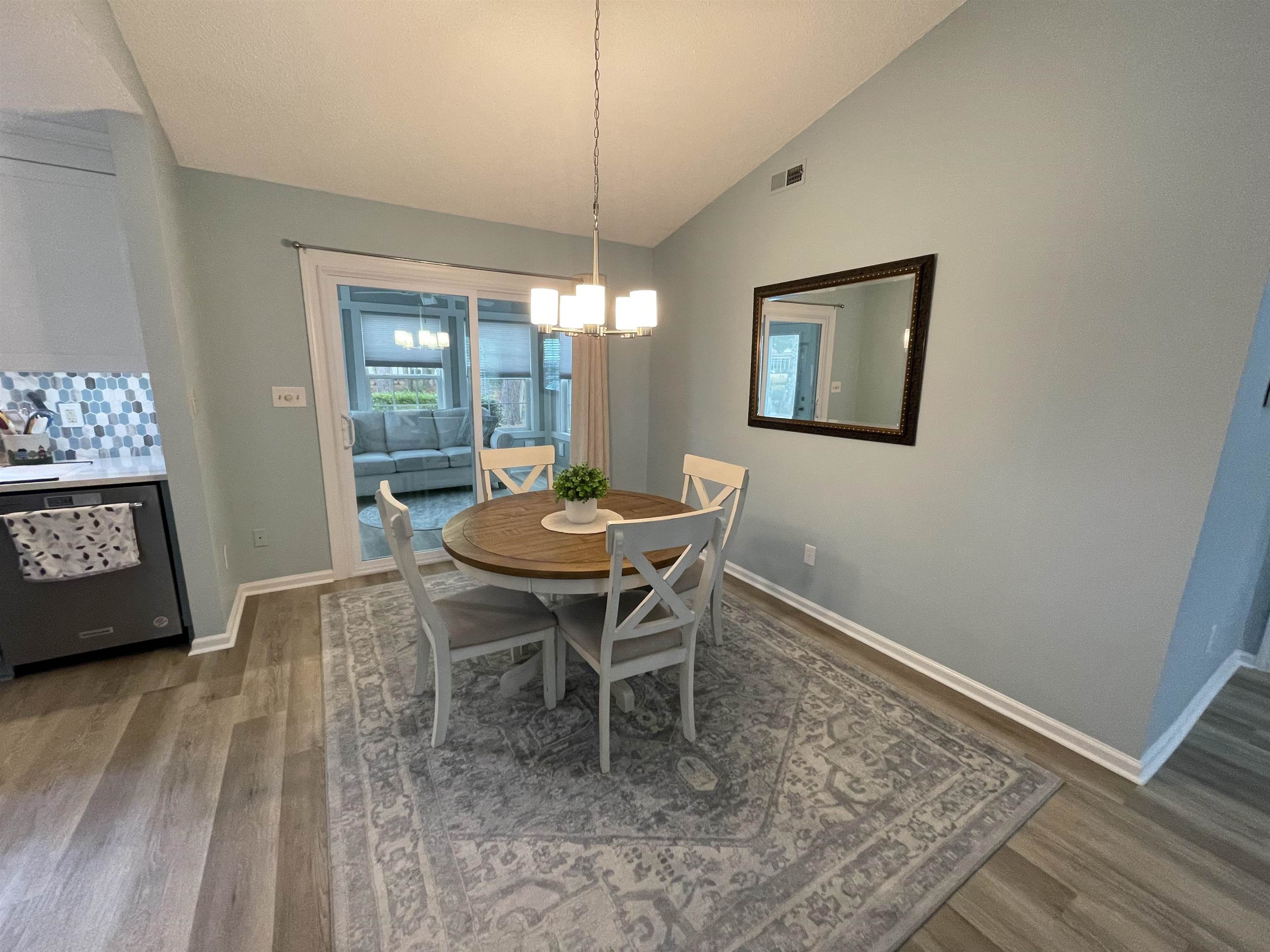505 Night Heron Court Murrells Inlet, SC 29576 - Photo 6 of 27 Dining room with lofted ceiling, dark wood-style floors, and a chandelier