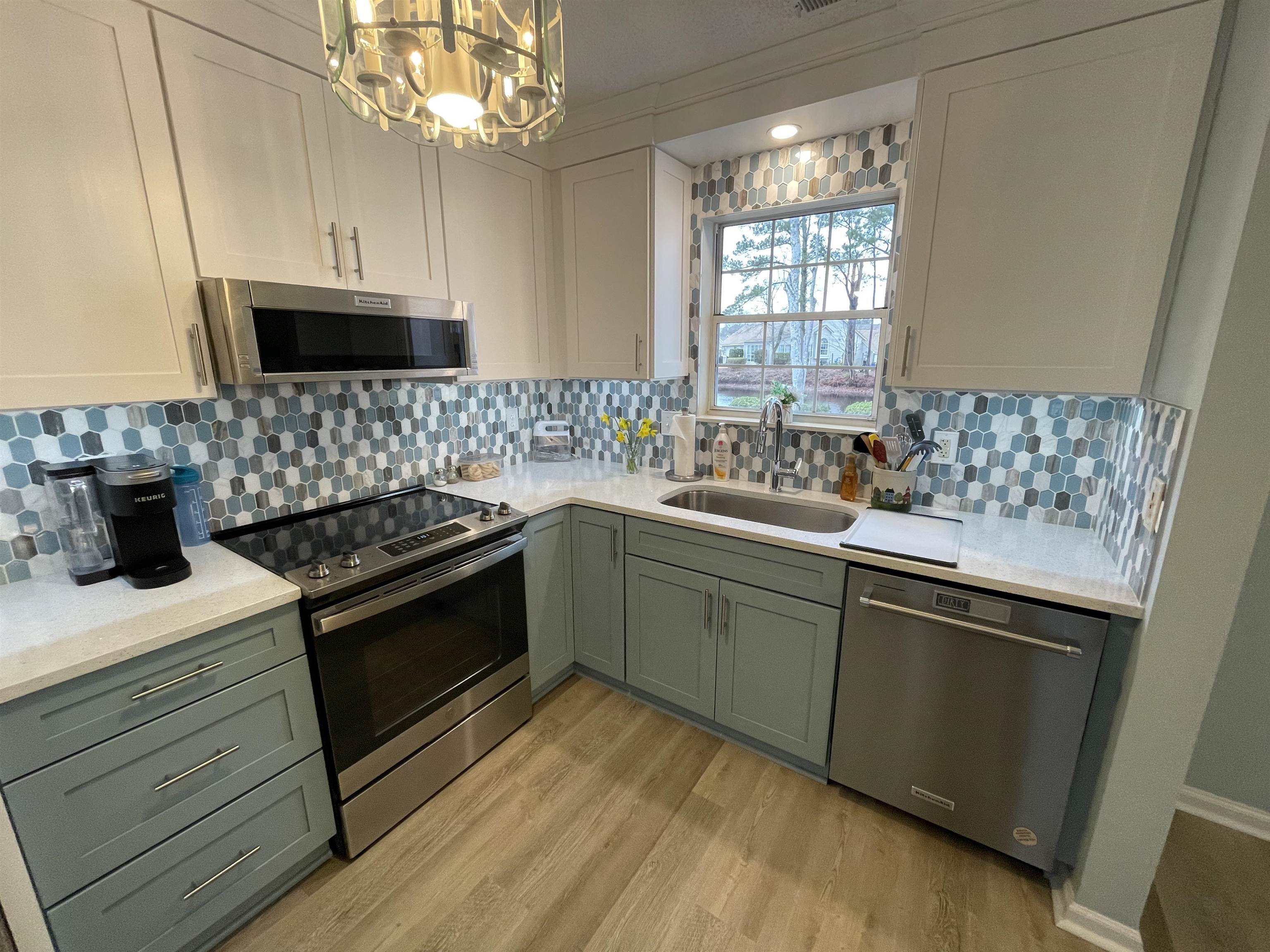 505 Night Heron Court Murrells Inlet, SC 29576 - Photo 8 of 27 Kitchen with stainless steel appliances, light stone countertops, decorative backsplash, and light wood-style floors