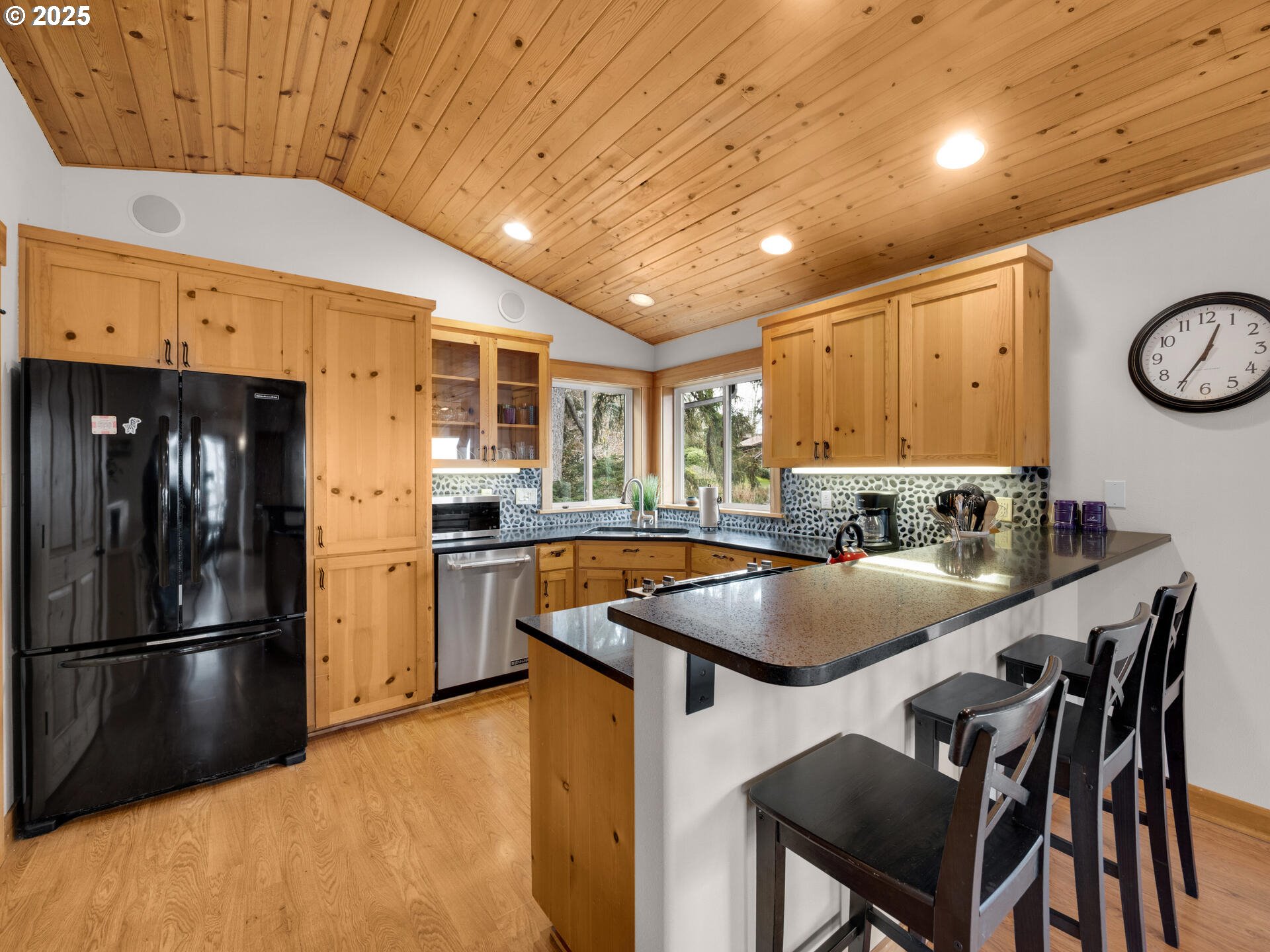 8435 Treasure Rocks Road Nehalem, OR 97131 - Photo 12 of 41 a kitchen with a table chairs refrigerator and cabinets