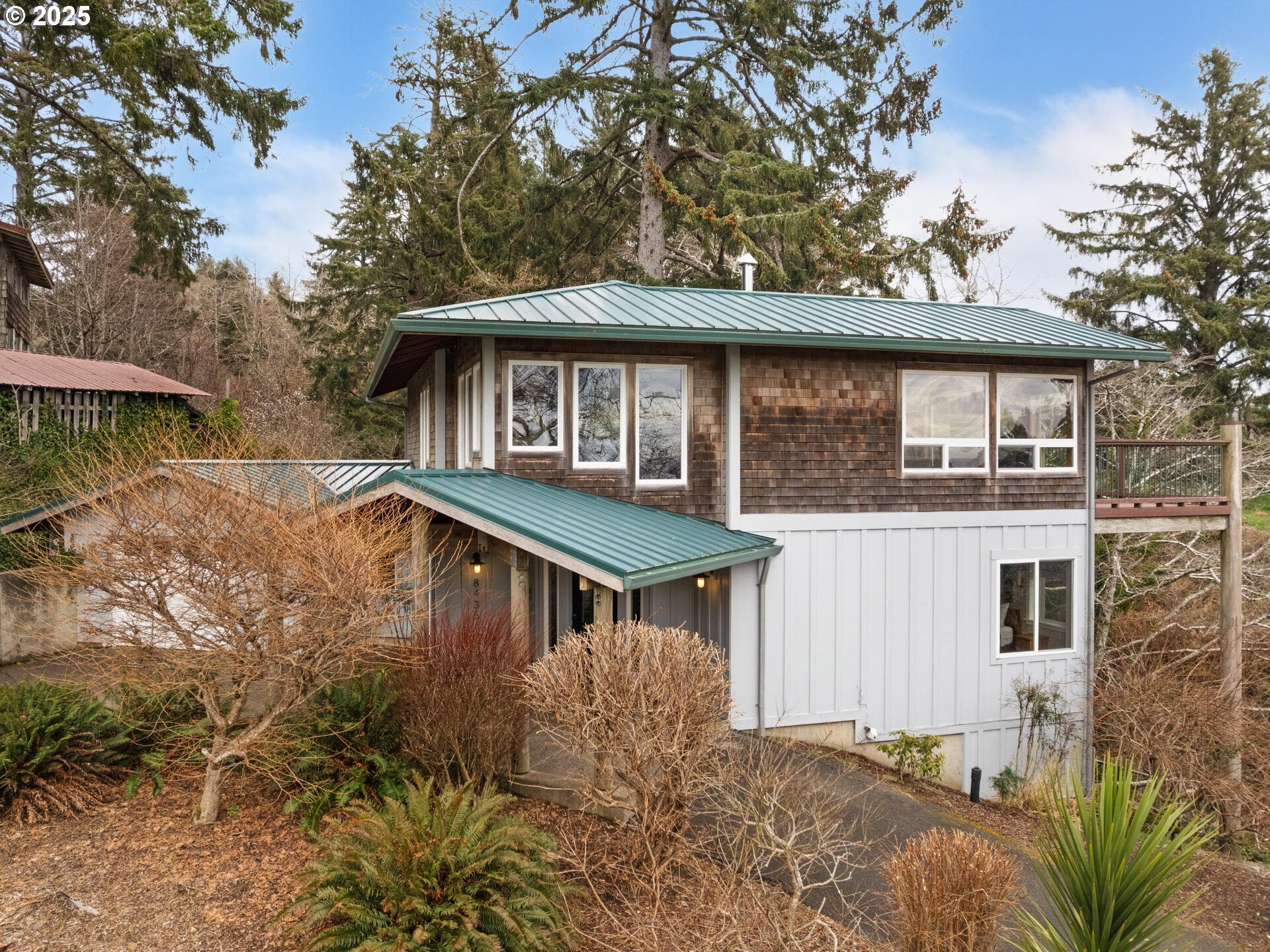 8435 Treasure Rocks Road Nehalem, OR 97131 - Photo 3 of 41 a backyard of a house with table and chairs under an umbrella