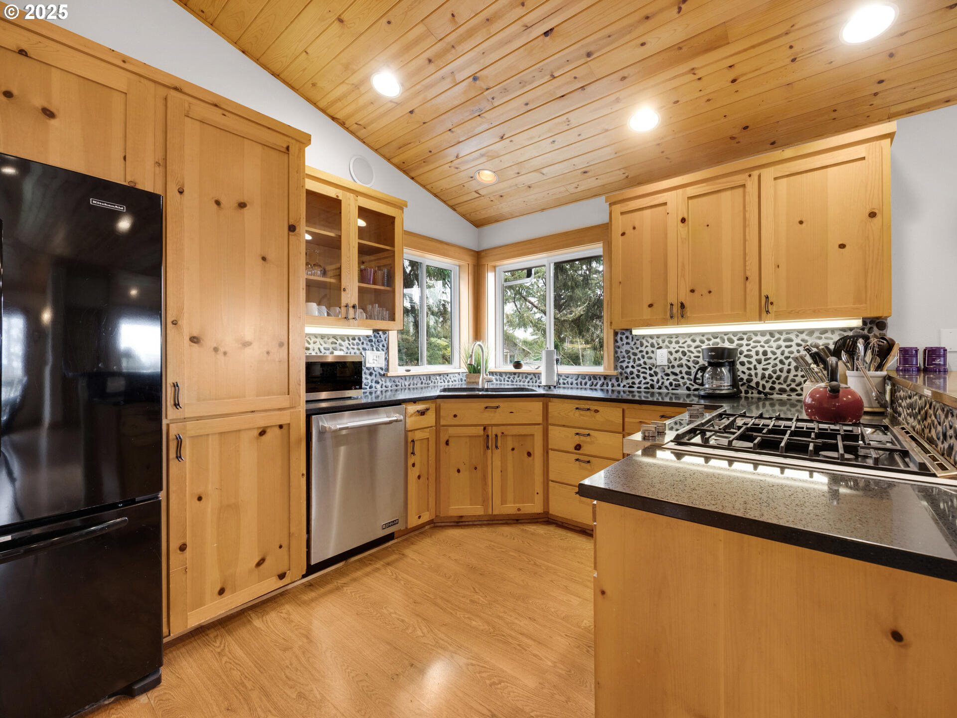 8435 Treasure Rocks Road Nehalem, OR 97131 - Photo 10 of 41 a kitchen with stainless steel appliances granite countertop a refrigerator a sink dishwasher a stove and white countertops with wooden floor