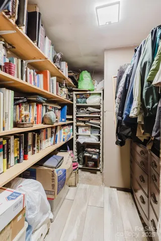 a view of walk in closet with clothes and shoes
