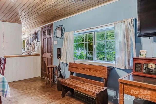 a sitting area with wooden floor and furniture