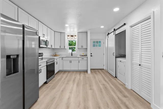 a kitchen with white cabinets and stainless steel appliances