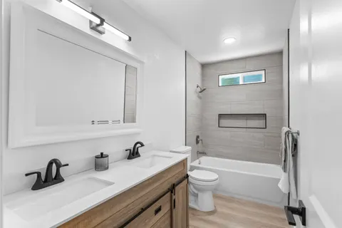 a bathroom with a granite countertop sink toilet and shower