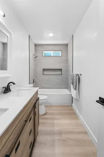 a bathroom with a granite countertop sink mirror vanity and bathtub