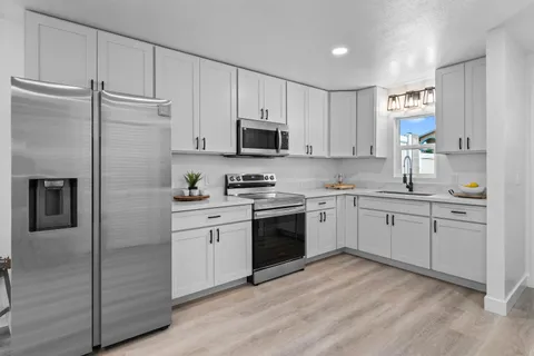 a kitchen with cabinets stainless steel appliances and a window