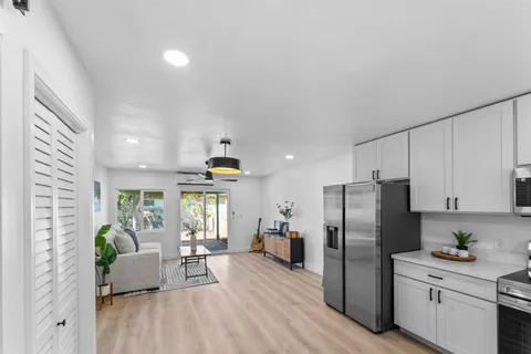 a living room with furniture and a refrigerator