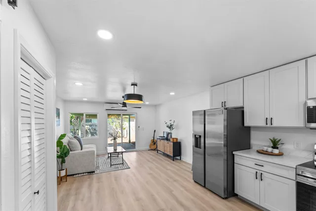 a living room with furniture and a refrigerator