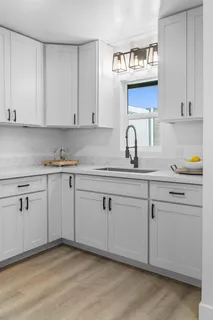 a kitchen with granite countertop white cabinets and white appliances