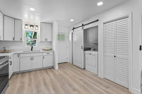 a kitchen with a refrigerator and white cabinets