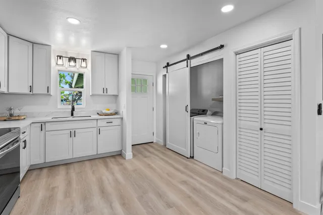 a kitchen with a refrigerator and white cabinets