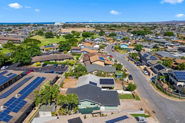 a view of a house with a yard and potted plants