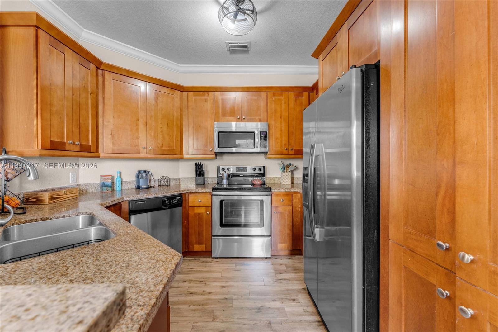 10012 Northwest 7th Street, Unit 206 Miami, FL 33172 - Photo 2 of 35 a kitchen with stainless steel appliances granite countertop a refrigerator a stove and a sink with wooden floor