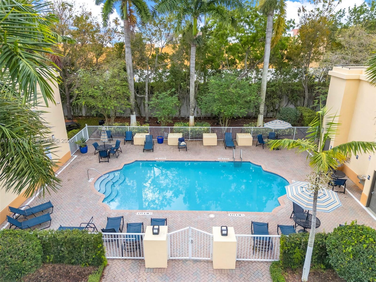10012 Northwest 7th Street, Unit 206 Miami, FL 33172 - Photo 5 of 35 an aerial view of a house having patio with swimming pool and sitting area