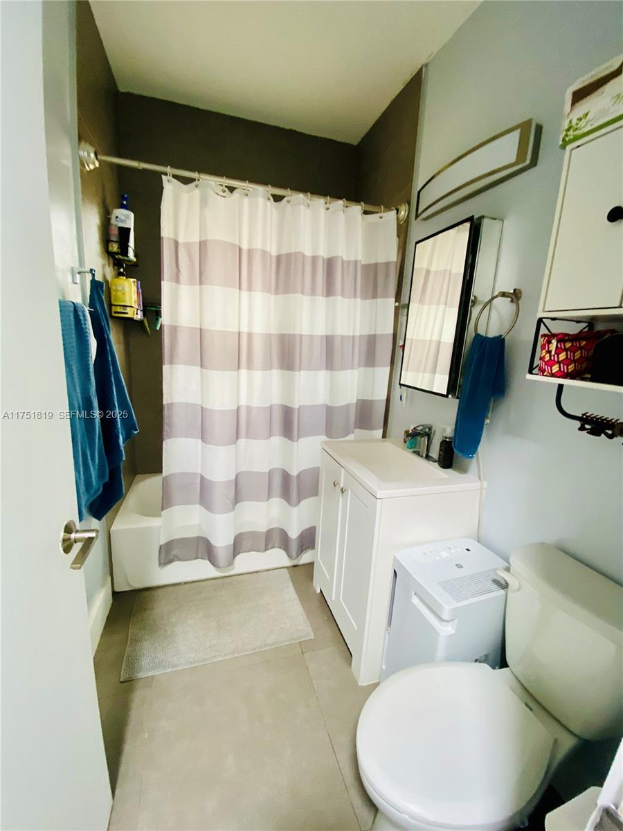 200 Azure Way Miami Springs, FL 33166 - Photo 42 of 54 a white toilet sitting next to a bathroom sink and tub