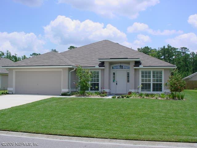 a front view of a house with a garden and yard