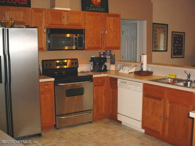 3547 Whisper Creek Boulevard Middleburg, FL 32068 - Photo 6 of 10 a kitchen with stainless steel appliances granite countertop a stove microwave and refrigerator