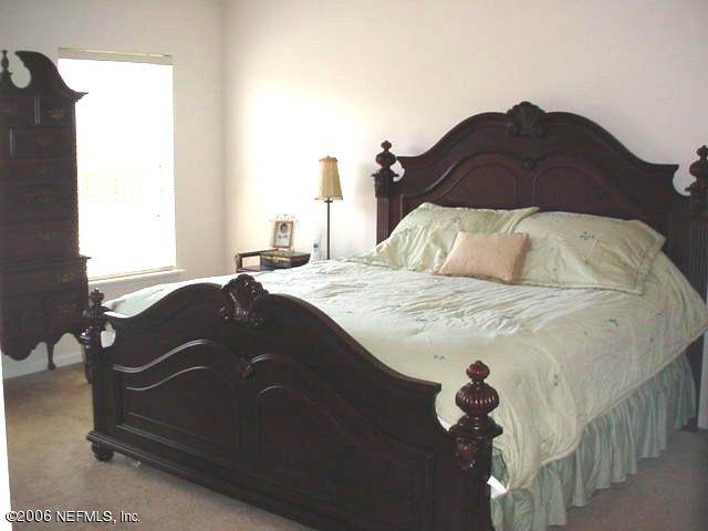 3547 Whisper Creek Boulevard Middleburg, FL 32068 - Photo 8 of 10 a bed sitting in a bedroom next to a window and a picture of the floor