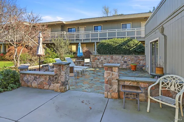 a view of a house with brick walls and a yard with plants