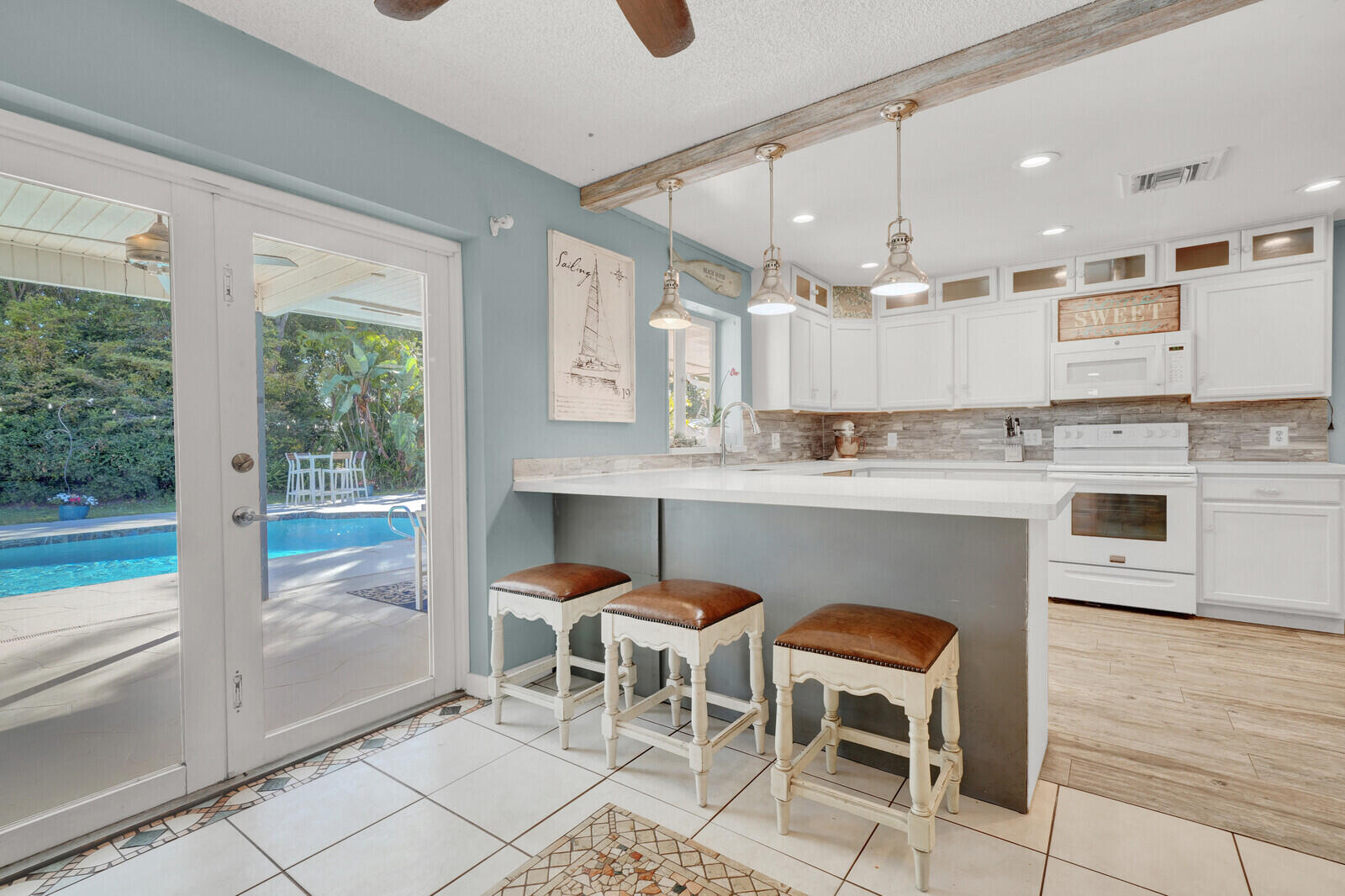 10406 Sleepy Brook Way Boca Raton, FL 33428 - Photo 6 of 36 a kitchen with a cabinets and chairs