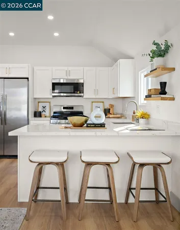 a kitchen with white cabinets and stainless steel appliances