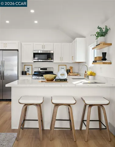 a kitchen with white cabinets and stainless steel appliances