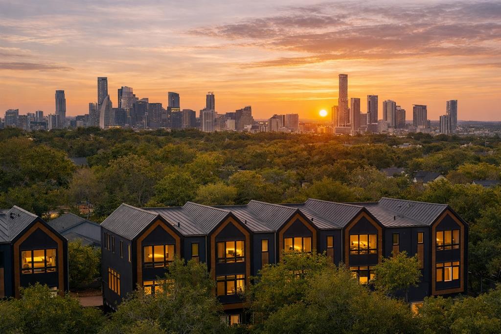 4101 Menchaca Road, Unit 102 Austin, TX 78704 - Photo 11 of 14 City skyline views with a vibrant sunset over a modern multi-family dwelling.