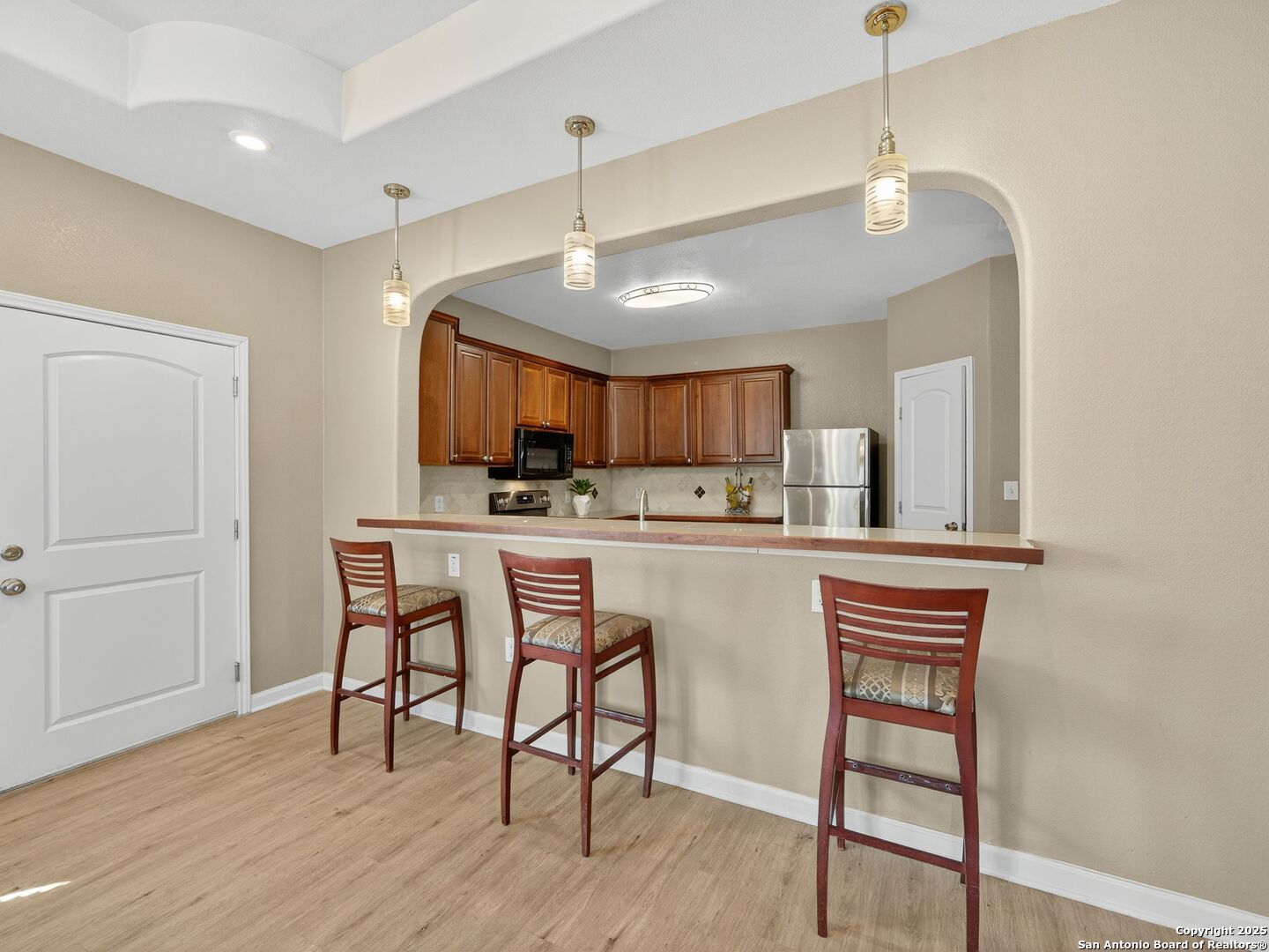 605 Meadow Gate Converse, TX 78109 - Photo 12 of 27 a kitchen with stainless steel appliances kitchen island wooden floors and white cabinets