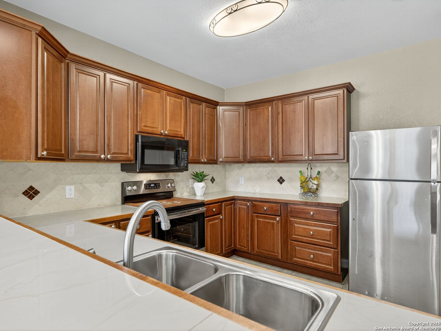 605 Meadow Gate Converse, TX 78109 - Photo 13 of 27 a kitchen with stainless steel appliances granite countertop a refrigerator sink and cabinets