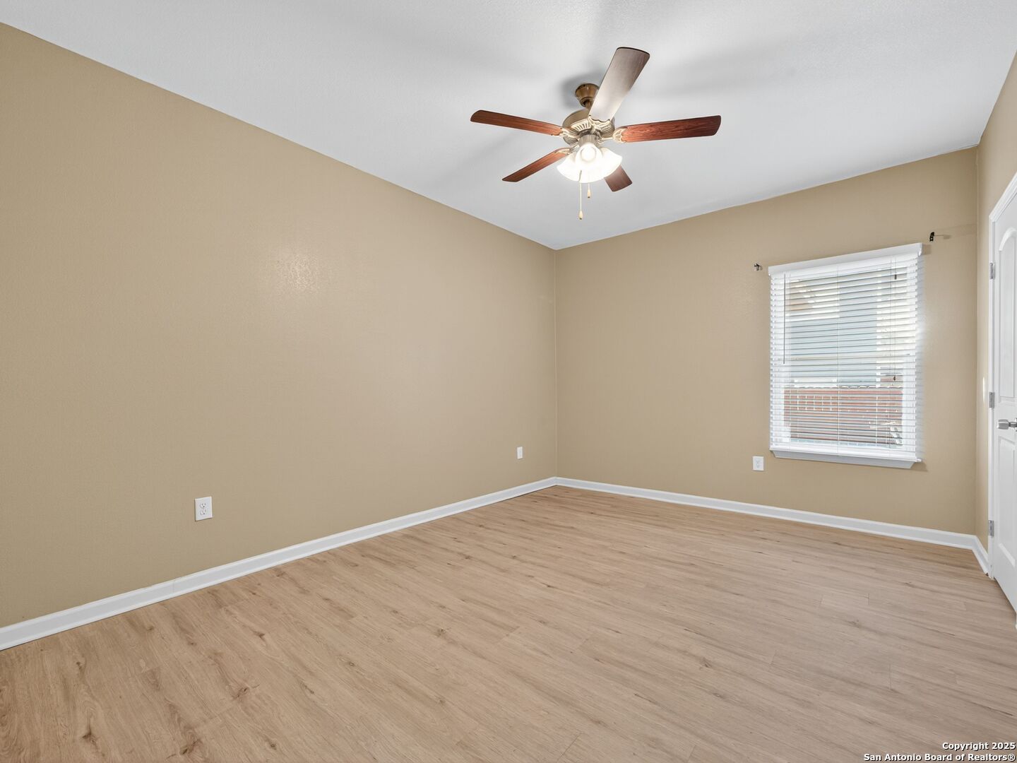 605 Meadow Gate Converse, TX 78109 - Photo 22 of 27 an empty room with wooden floor fan and windows