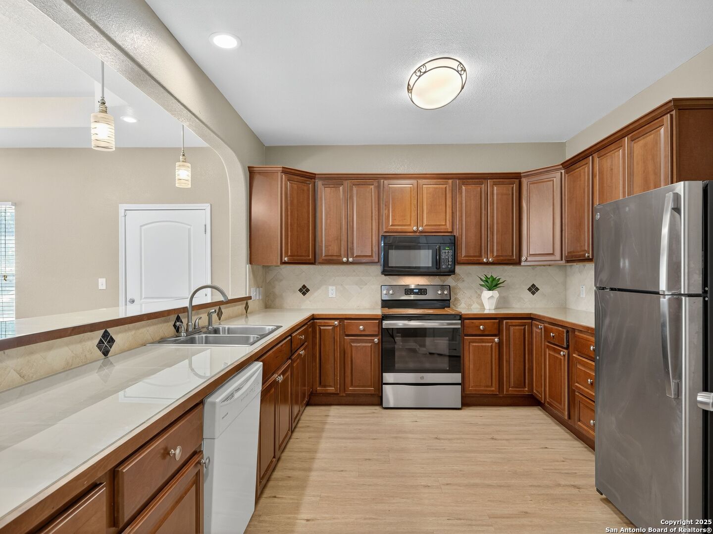 605 Meadow Gate Converse, TX 78109 - Photo 9 of 27 a kitchen with stainless steel appliances granite countertop a stove top oven a refrigerator a sink and dishwasher