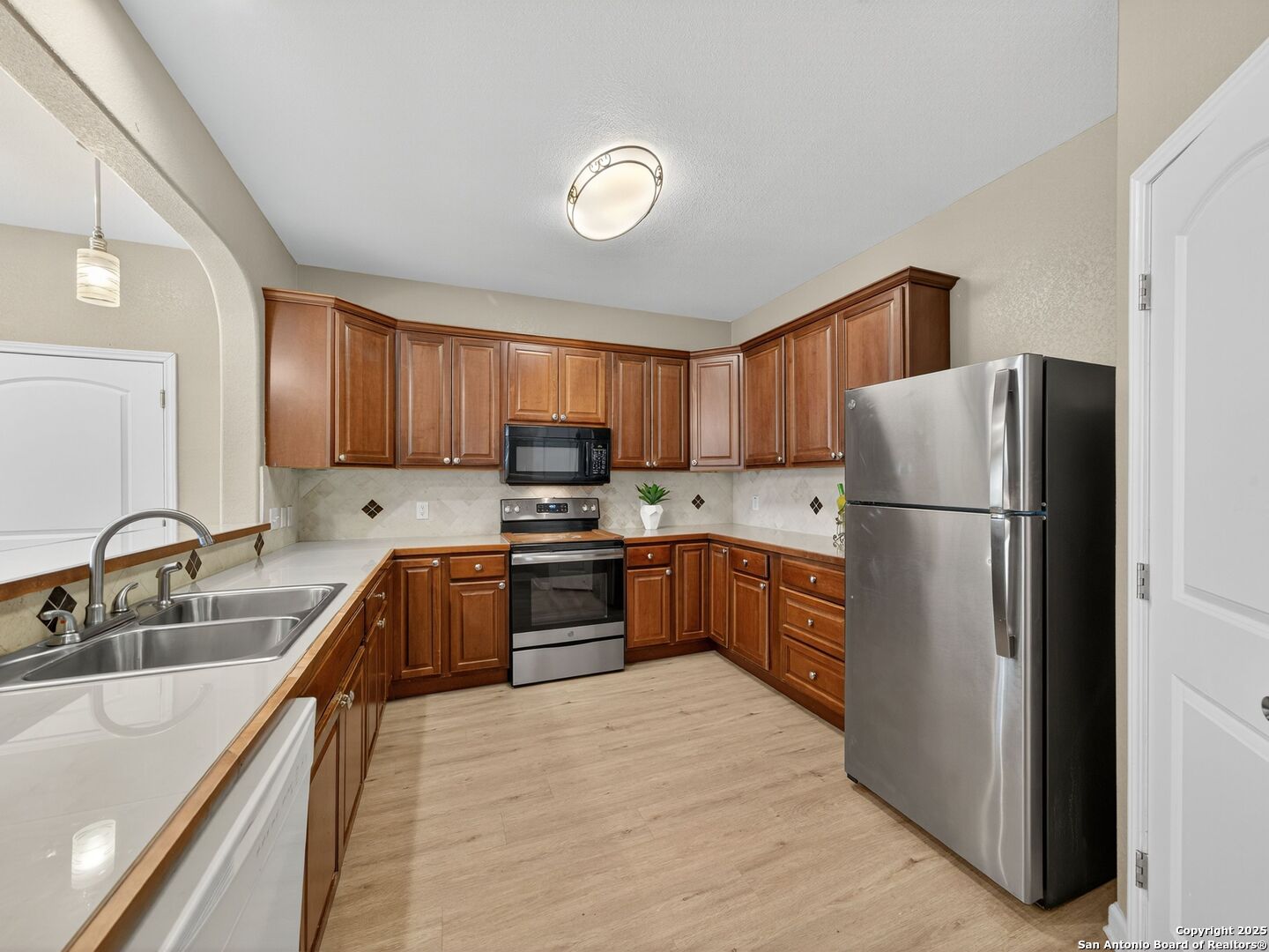 605 Meadow Gate Converse, TX 78109 - Photo 10 of 27 a kitchen with granite countertop stainless steel appliances a refrigerator stove top oven and sink