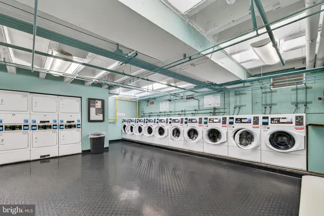 a utility room with stainless steel appliances granite countertop lots of white cabinets